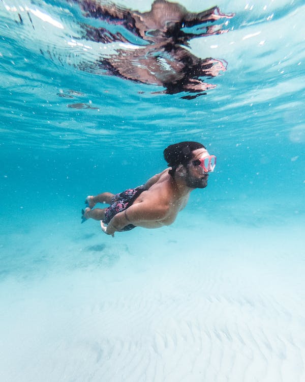 male swimmer swimming under water with anti fogged goggle