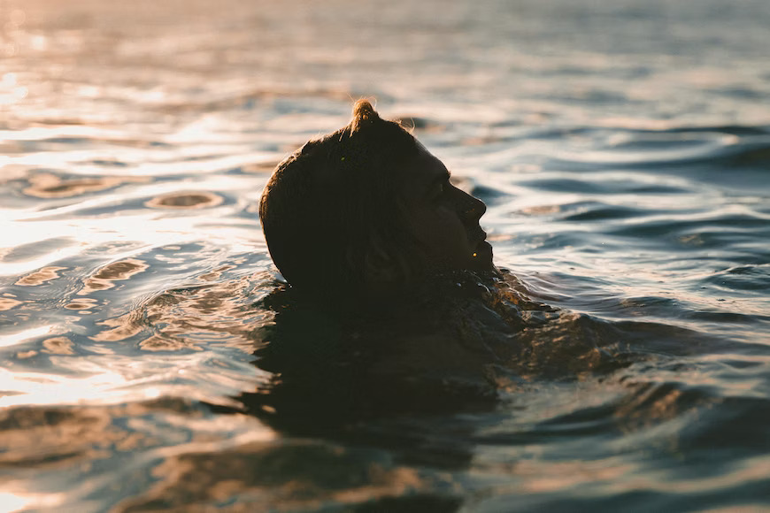 swimmer taking a dip in the swimming pool with sun shining