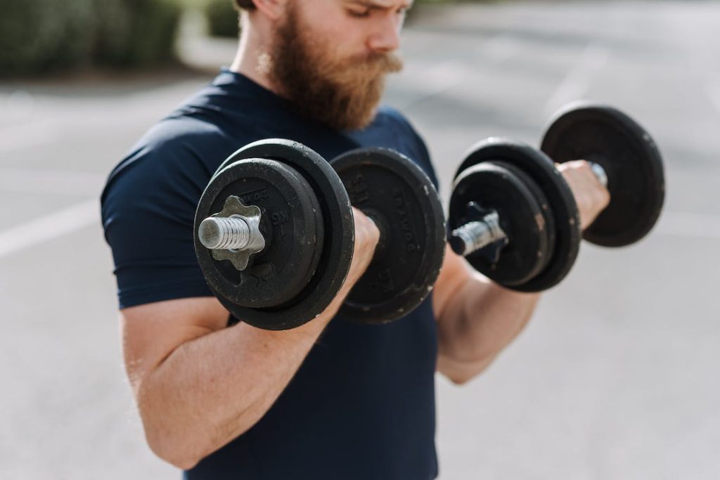 male swimmer lifting dumbbells 
